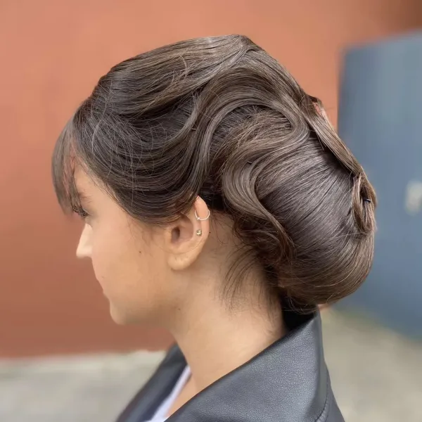 Chignon rétro volumineux avec frange ondulée, vu de trois quarts