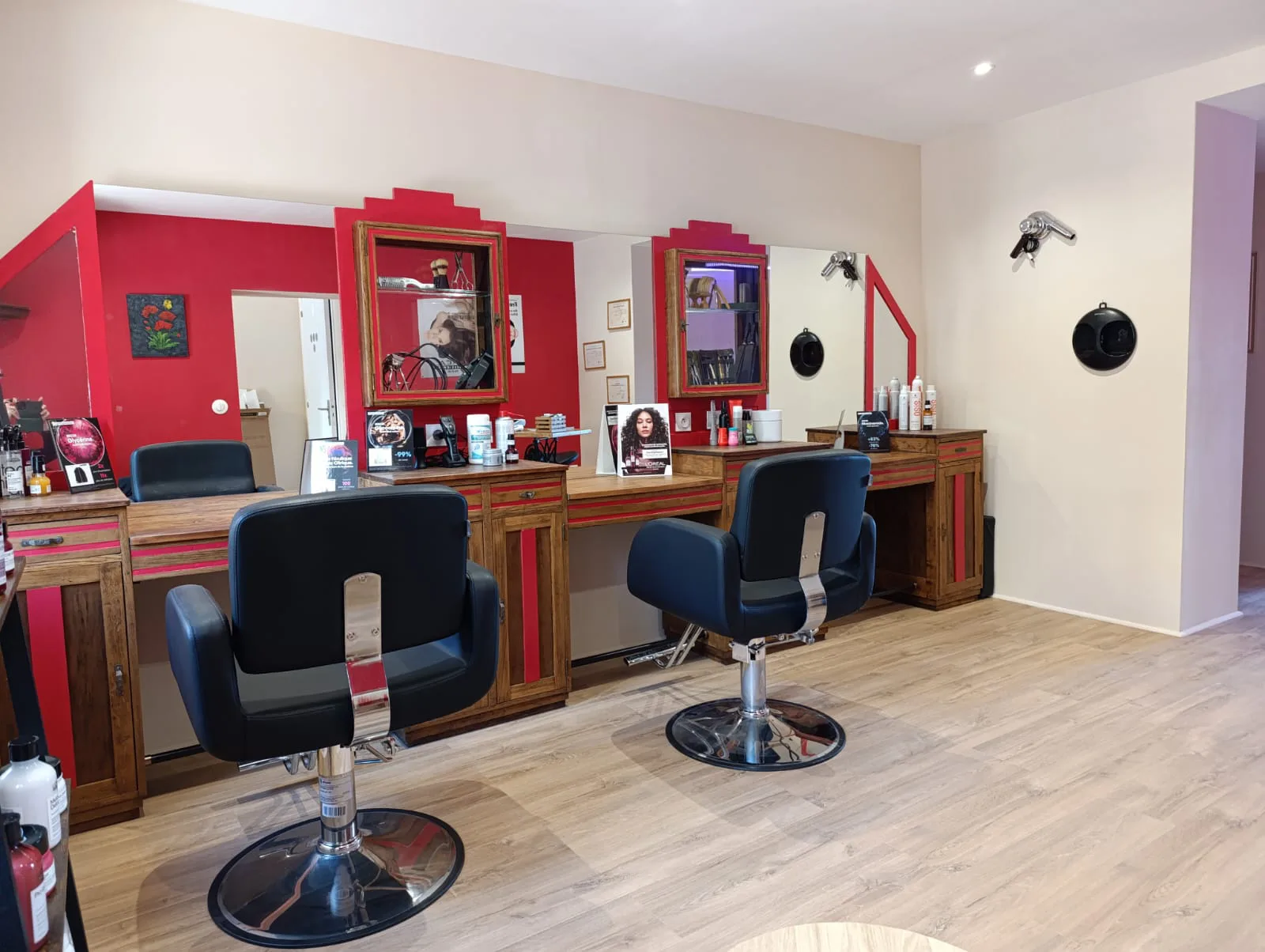 Les postes de coiffage aux miroirs rouges du salon La Boucle Rouge à Œting