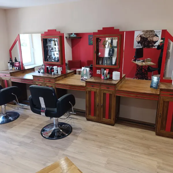 Intérieur du salon de coiffure La Boucle Rouge à Œting : postes de coiffage aux miroirs rouges